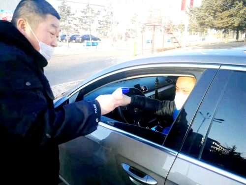 图为东荣二矿保卫科干警严格检查进出矿车辆，，，，，，，，对每名进矿职工都进行体温测量并登记。。。。。。